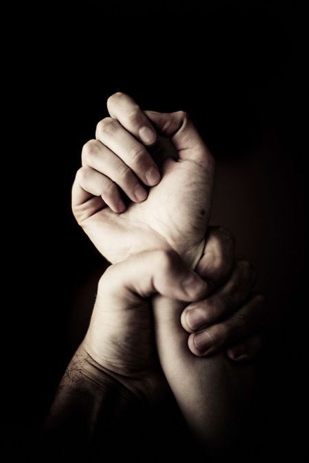 A hand with a tight grip on another hand