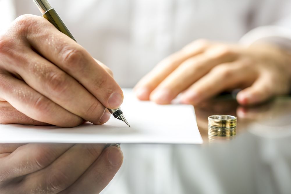 A closeup shot of a person signing a paper